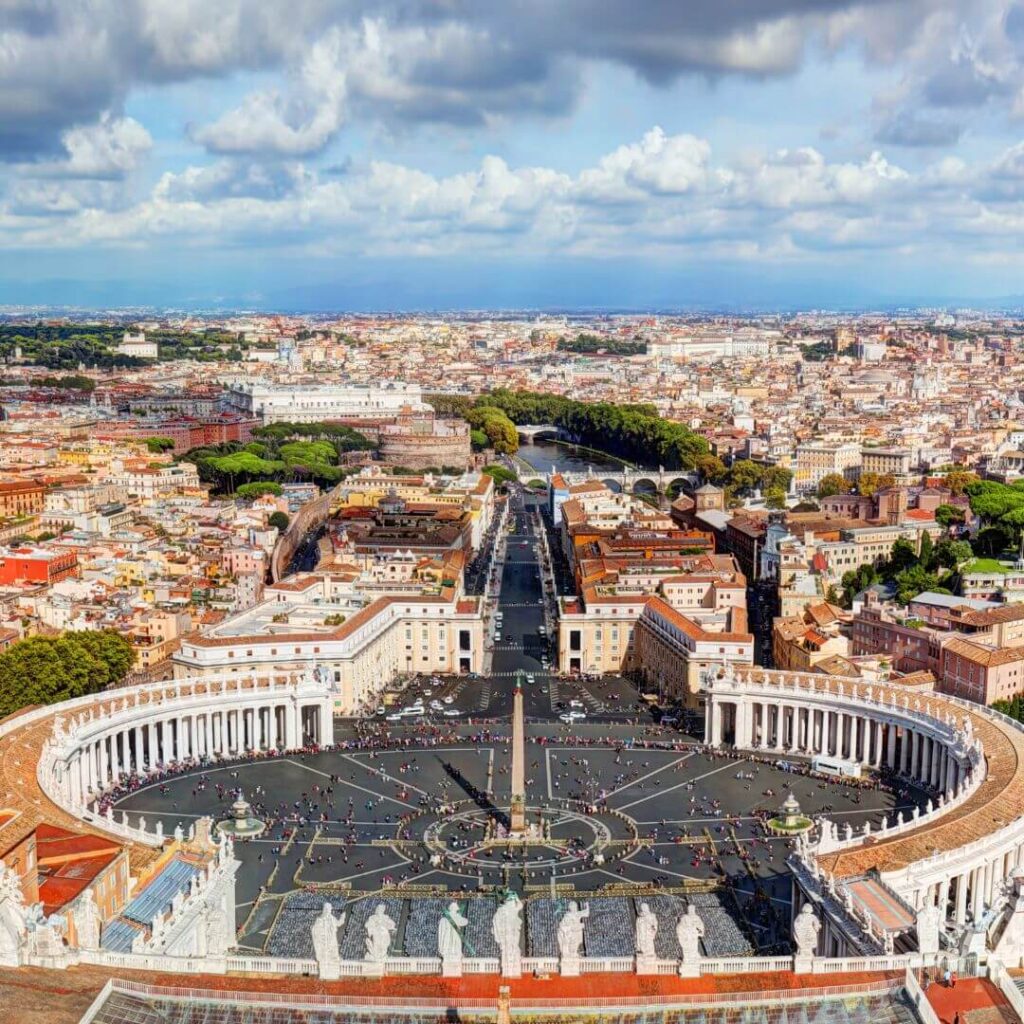The view over St. Peter's Square from the top of the dome, with Rome and the Tiber River beyond. You can see Castel San'Angelo next to the Tiber, and the columns, obelisk and fountains of the piazza.