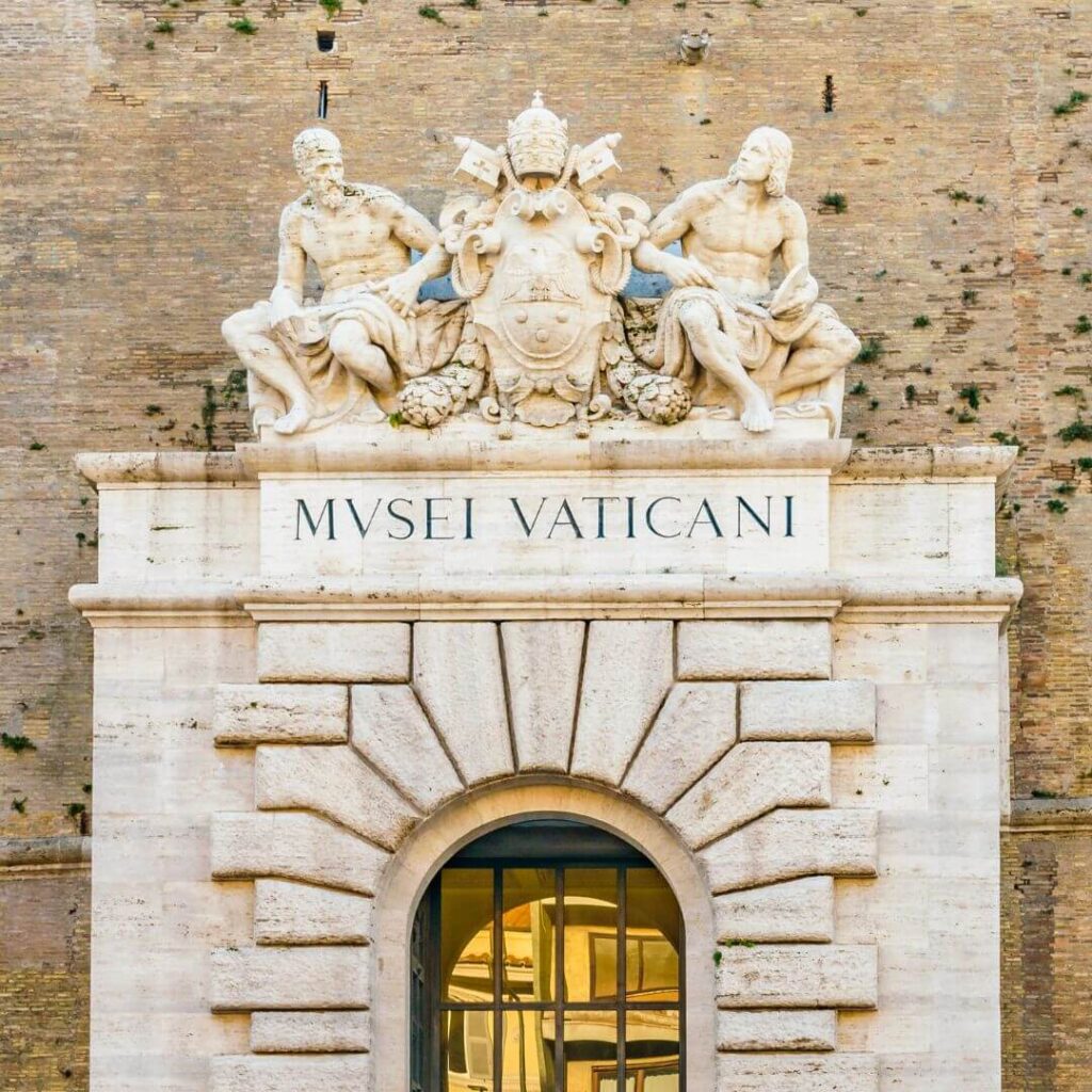 The entrance to the Vatican Museums in Vatican City, Rome Italy. Over the doorwway is a scuopture with the Papal coat of arms.