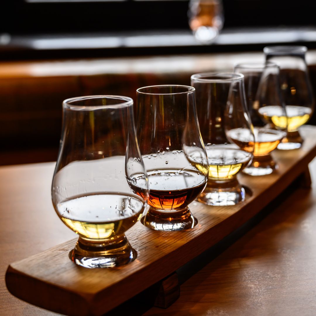 Scotch whisky on a wooden tray on a wooden table, set out as a whisky tasting flight