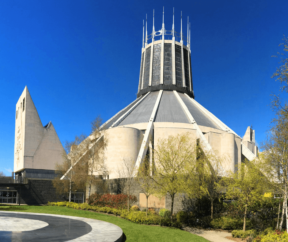Exterior of Liverpool Metropolitan Cathedral with its circular shape and tall lantern spire under blue sky