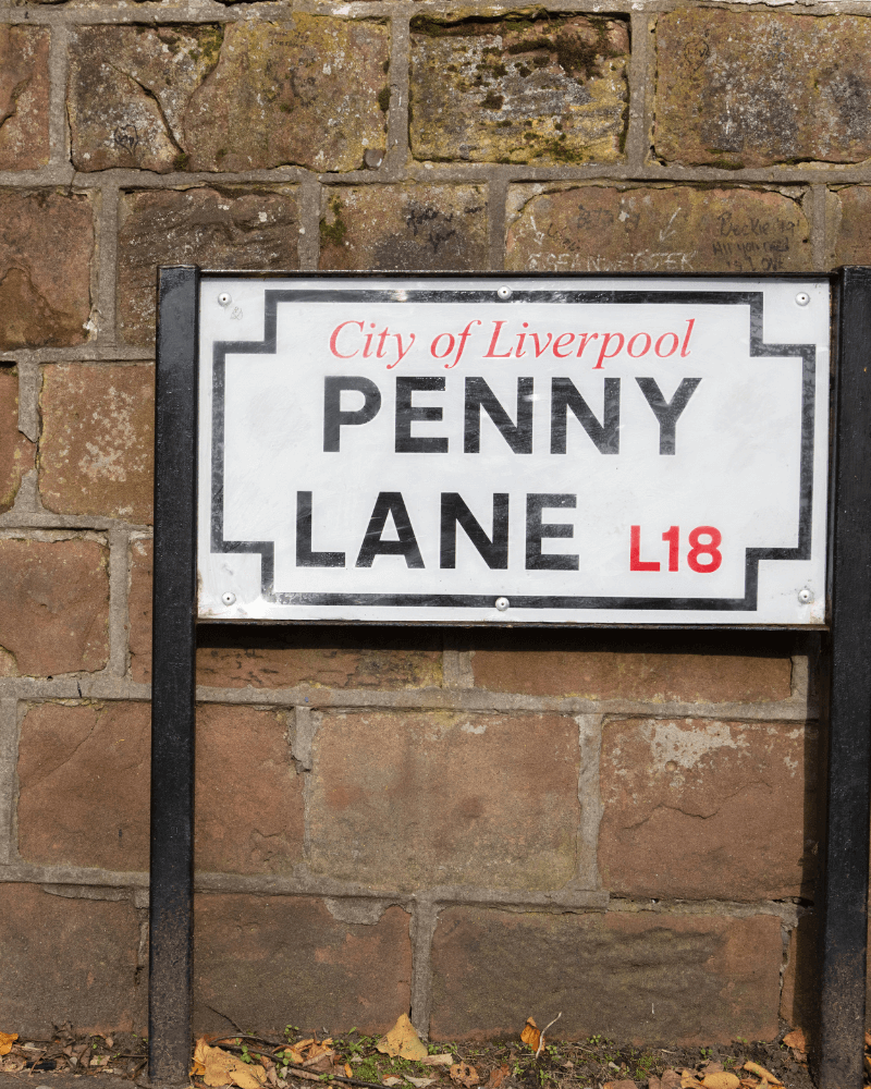 Street sign for Penny Lane in Liverpool, against a brick wall