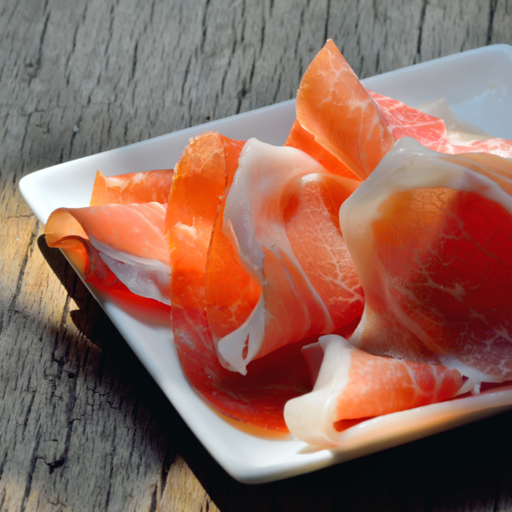 Sliced Prosciutto di Parma on a plate, one of Emilia-Romagna's most popular Italian specialties