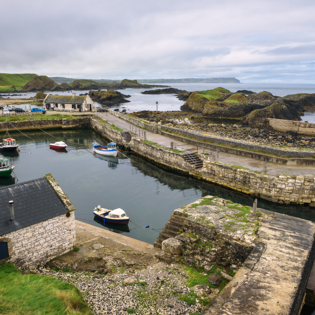 Ballintoy harbour, an enclosed harbour in Northern Ireland, with small fishing vessels and the coastline beyond