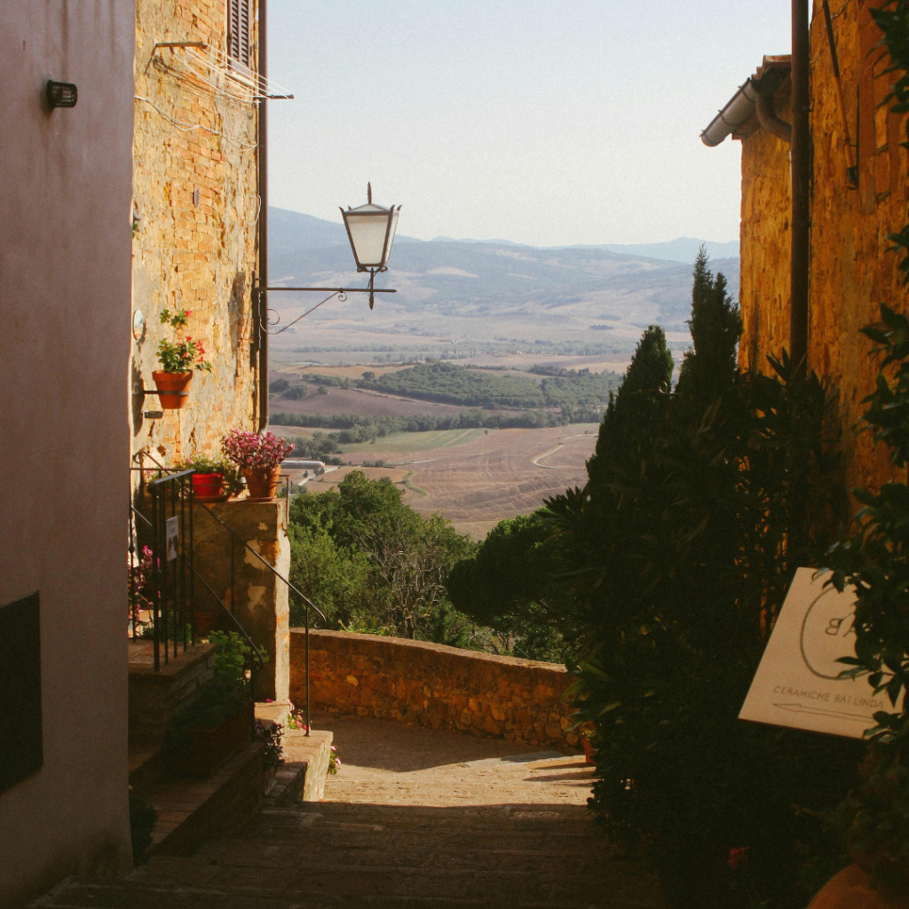 A view between buildings in Pienza, with the Tuscany Italy countryside beyond