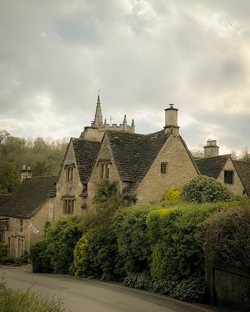 A house in Castle Combe with the tower of St. Andrews Church behind it