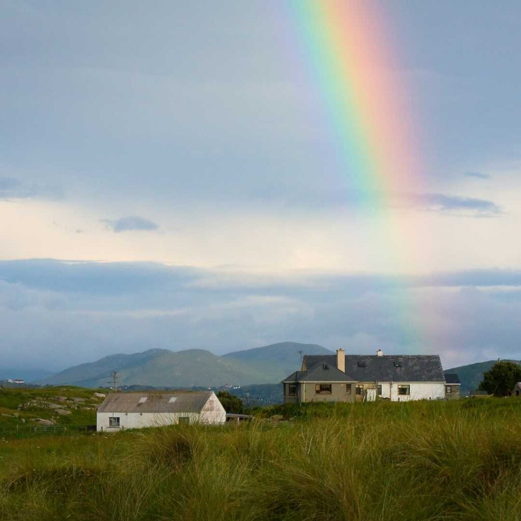 Irish house with rainbow in the sky above