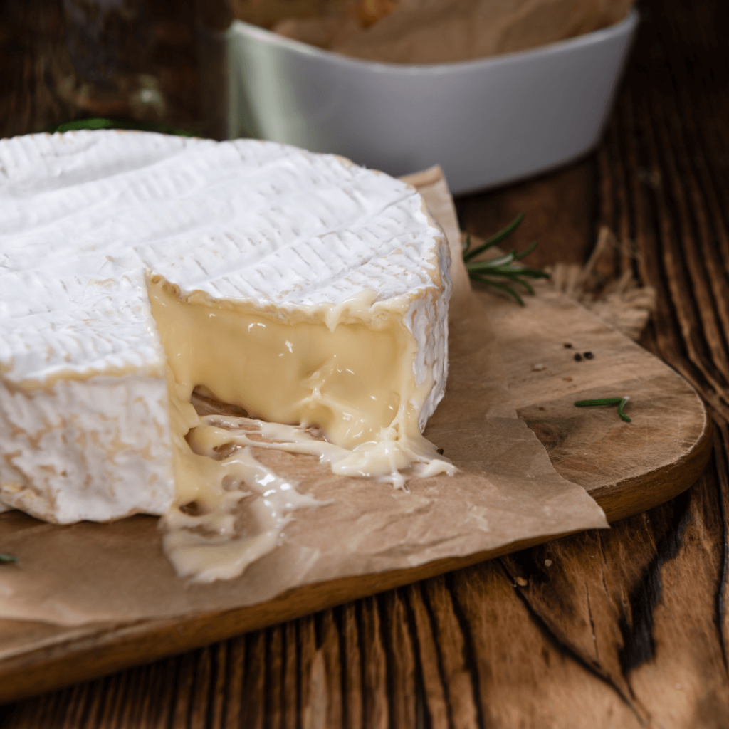 A wheel of Camembert with a wedge cut out, an example of regional french food from Normandy