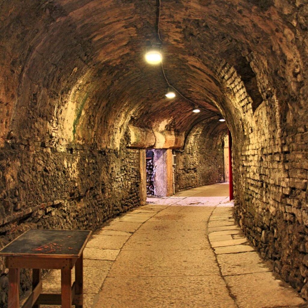 A lighted tunnel in the underground Paris Catacombs in the 14th Arrondissement