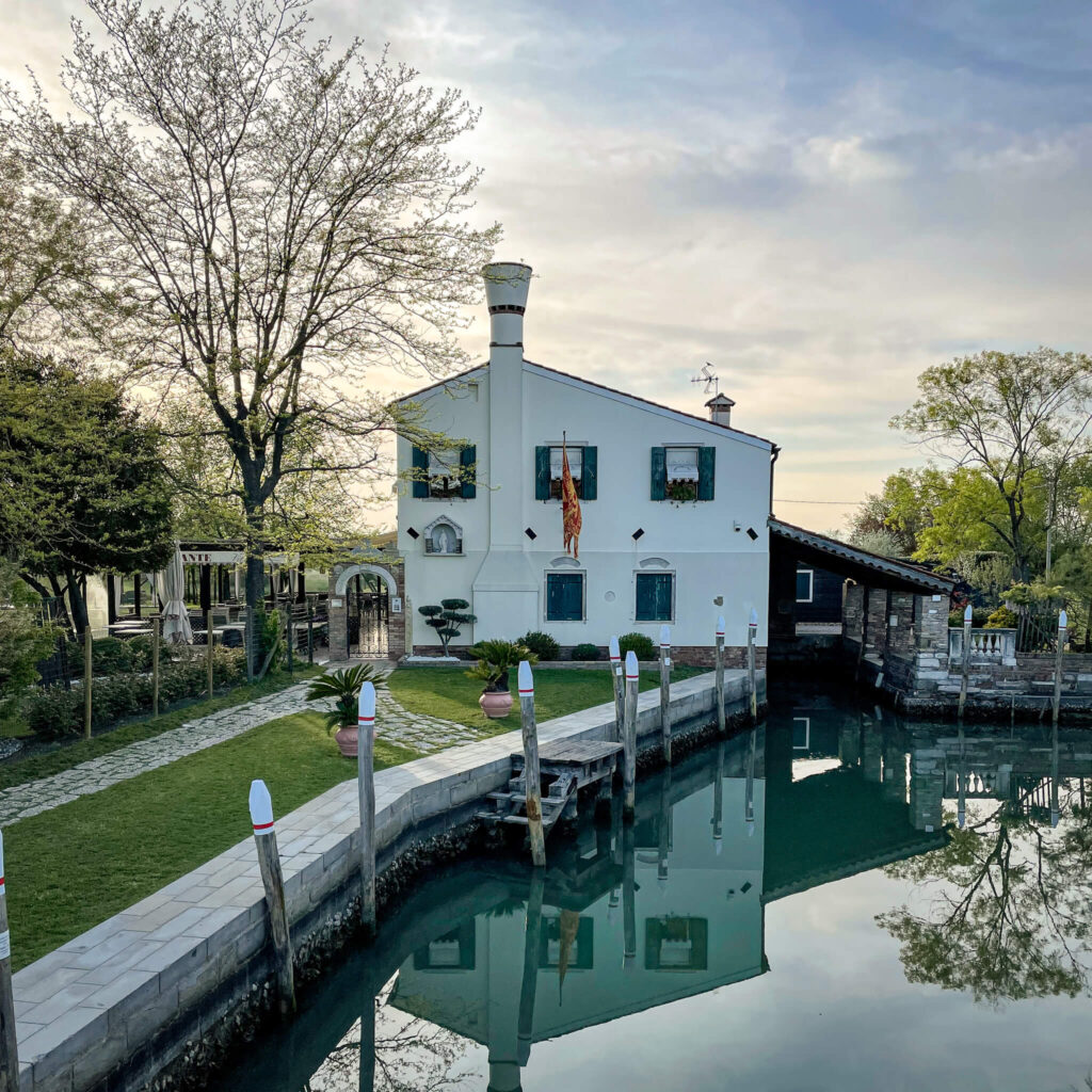 A white house on a canal on the island of Torcello in Venice, Italy