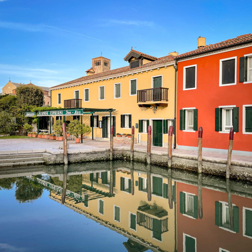 The front of the Locanda Cipriani reflected in the still water of the canal on the island of Torcello in Venice, Italy