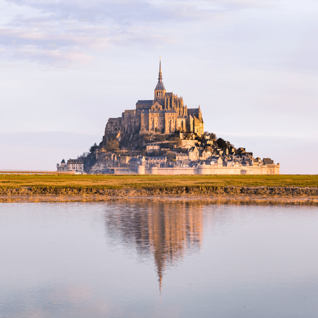 The commune of Mont St. Michel reflected in the surrounding tide flats, one of the common day trips from Paris