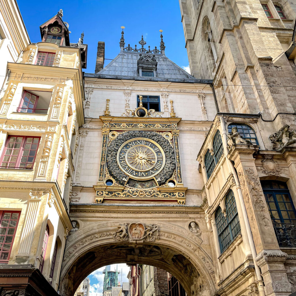 Looking up at the Gros Horloge in Rouen, one of the common day trips from Paris