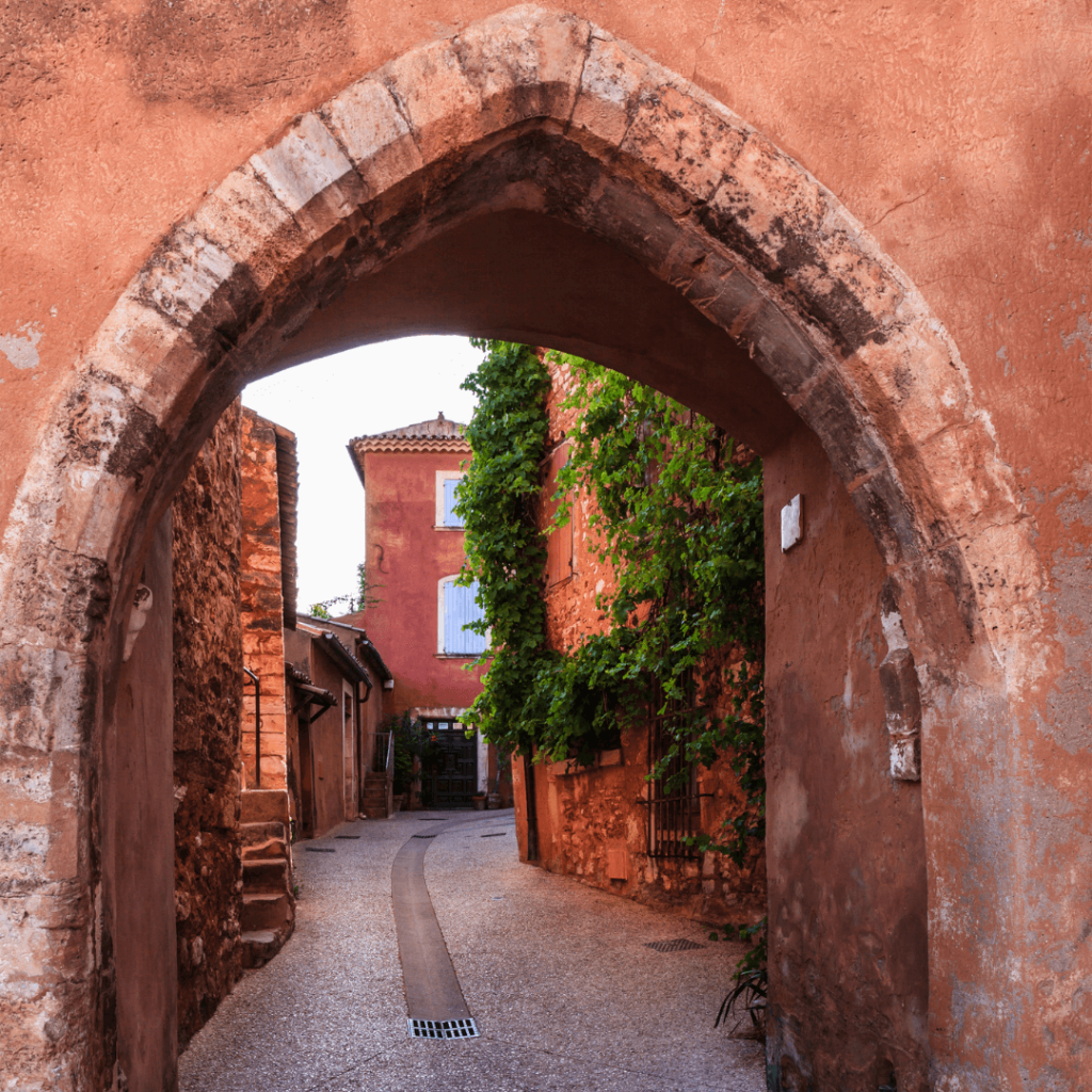 View through an archway of the ochre-hued buildings in the streets of Roussillon