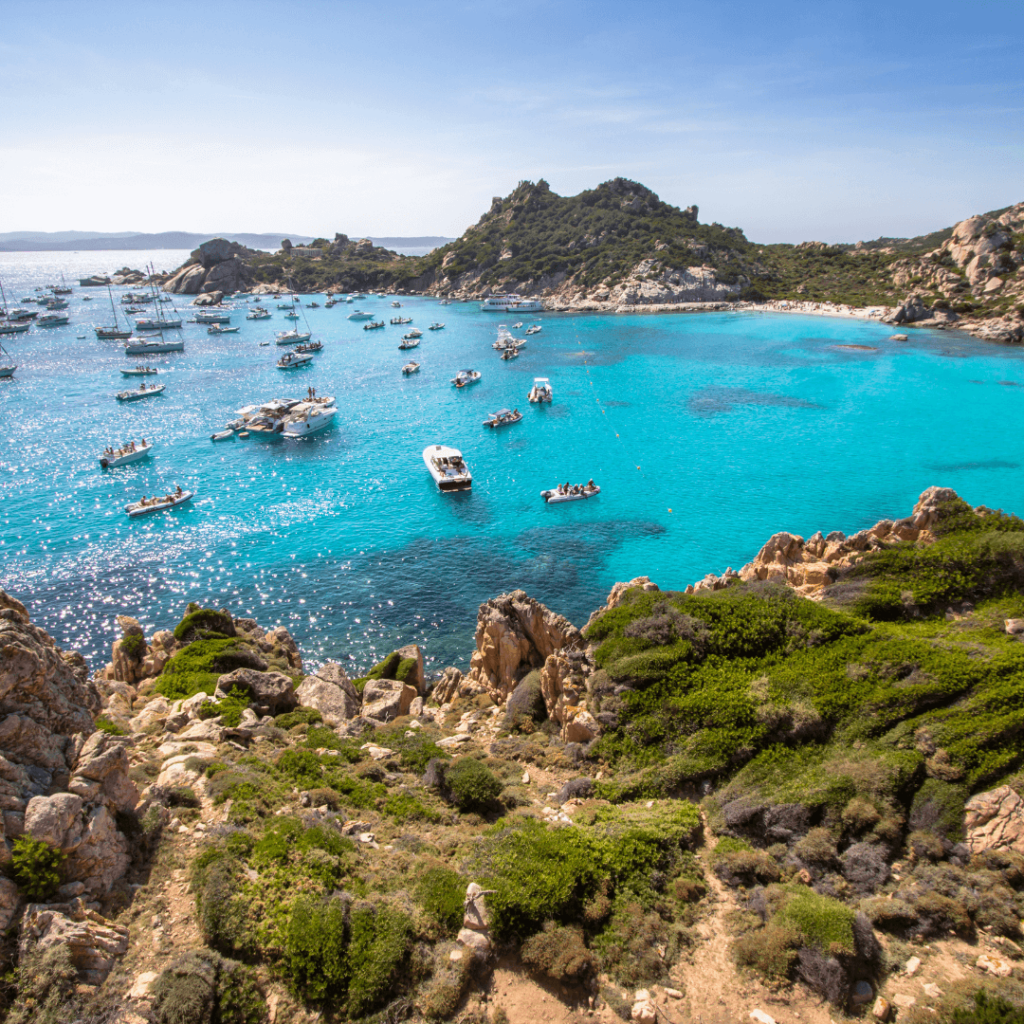 Clear, turquoise blue water with boats in the bay along Costa Smeralda (Turquoise Coast)