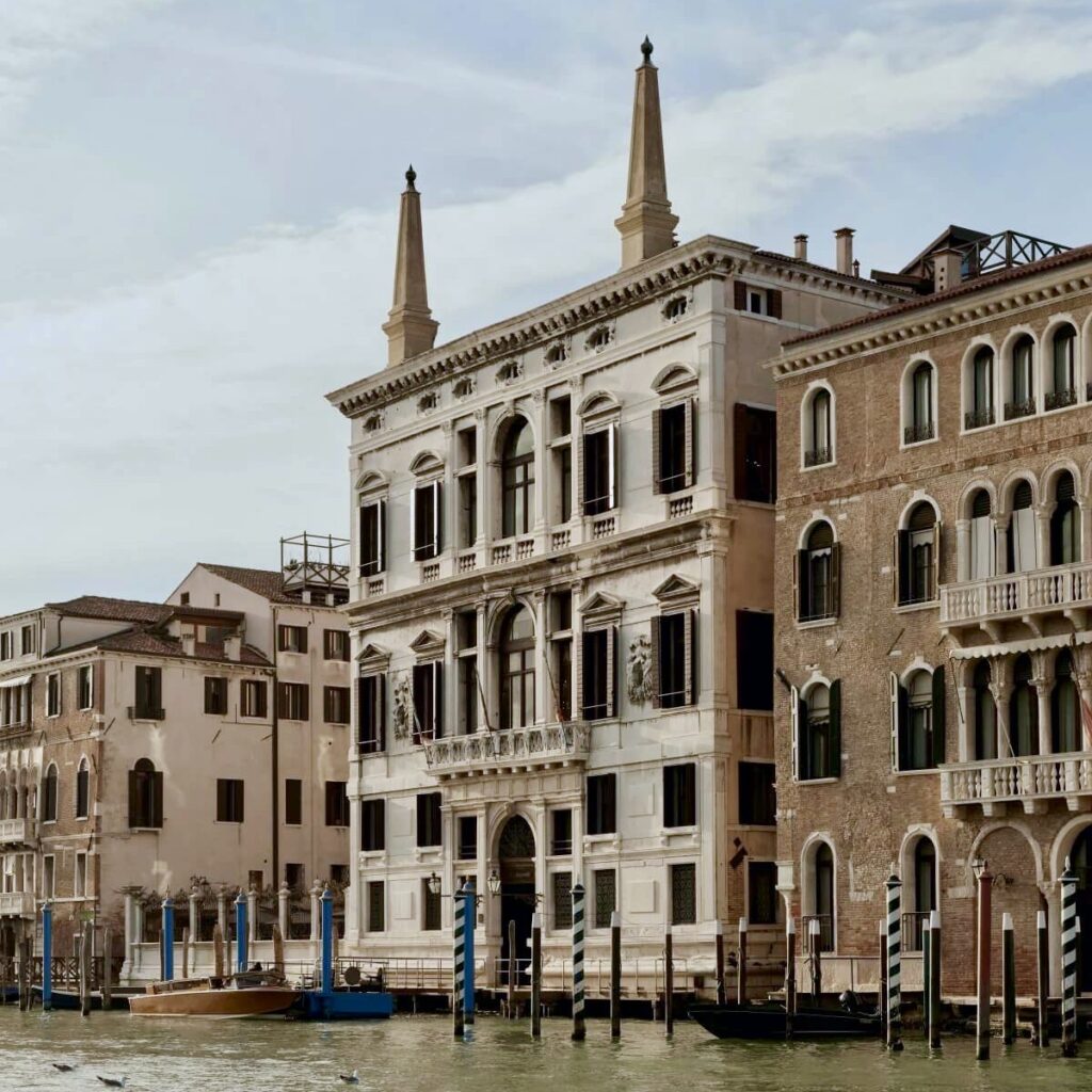 The beige exterior canal side view of the Aman hotel, one of the luxury hotels in Venice Italy, from the Grand Canal