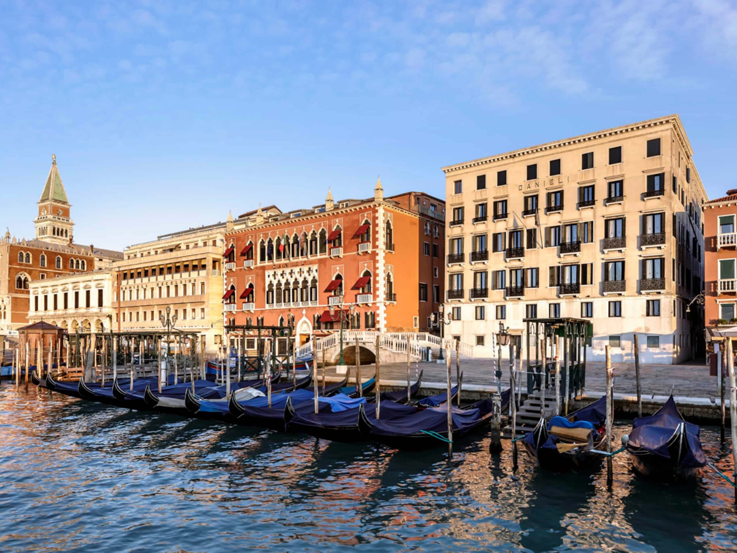 Exterior view of Hotel Danieli with gondolas floating at the edge of the Grand Canal