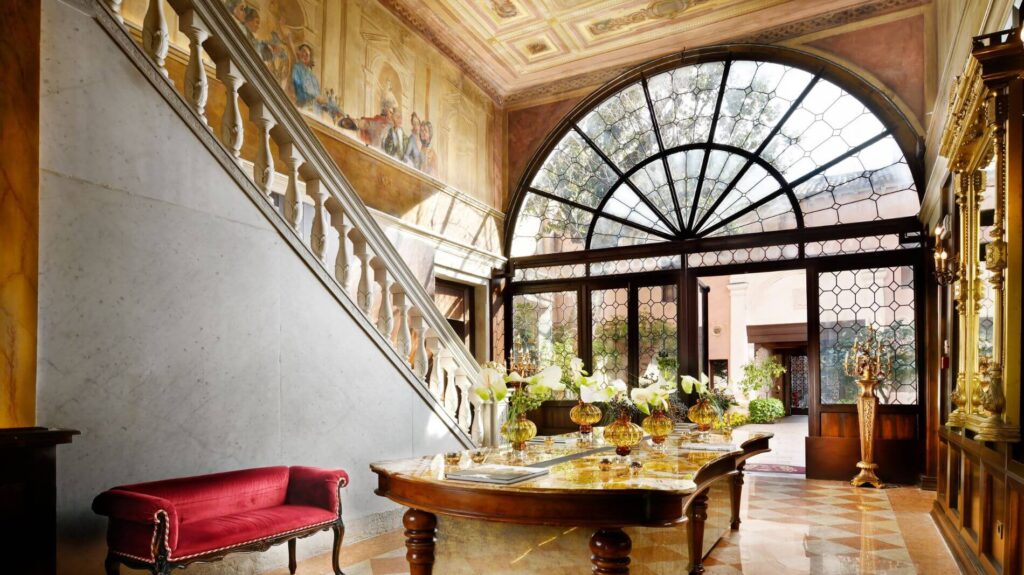 A wall of windows around the entrance door and elaborate reception area at Palazzo Venart, one of the luxury hotels in Venice, Italy along the Grand Canal